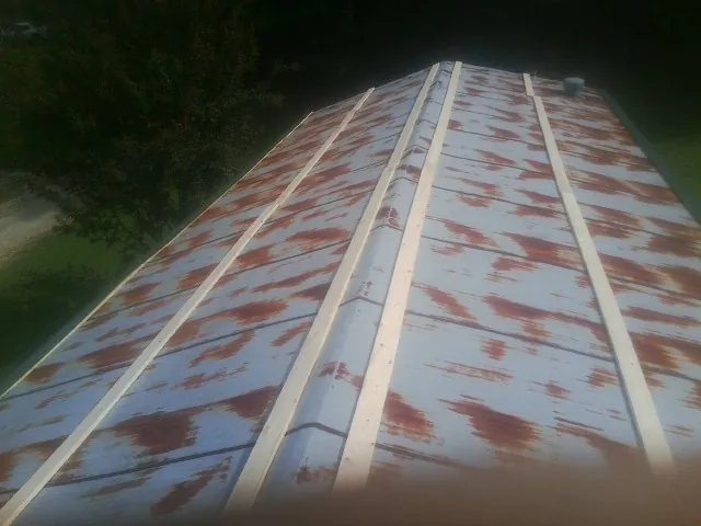 Rusted metal roof panels with new wood purlins before replacement — Storm Damage Roof Repair in Blacklick by Roofing Brothers