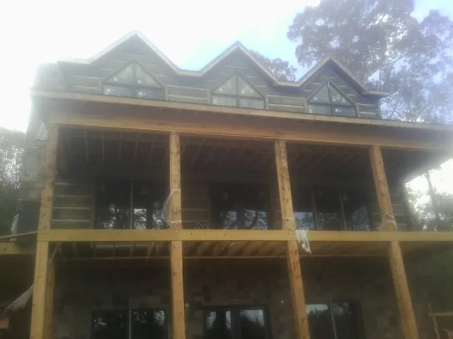 Dormers and porch framing on a large log home under construction — Roof Coating work by our crew in Blacklick