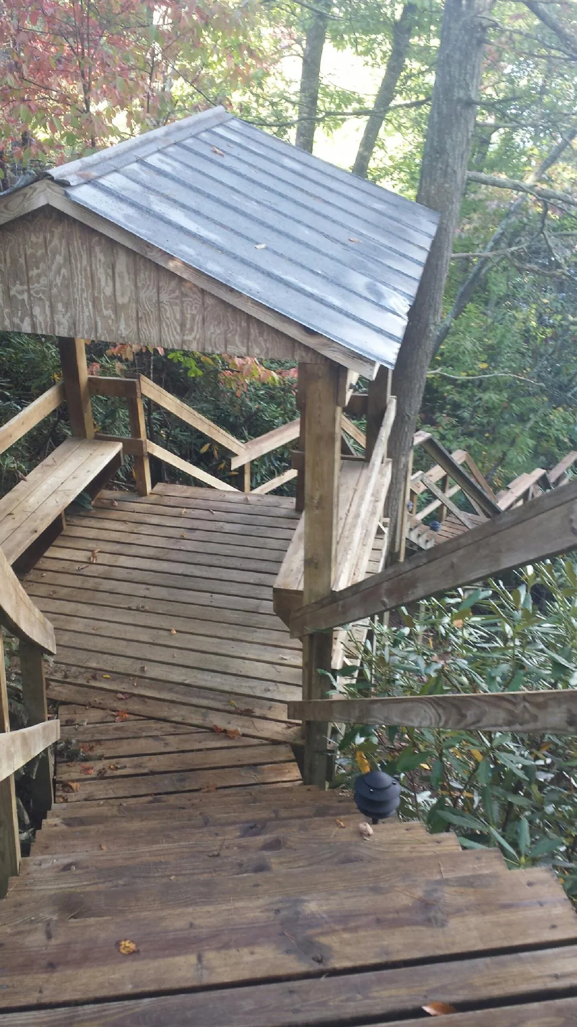 Metal roofed shelter over wooden steps on a wooded walkway — Skylight Repair & Installation work by our crew in Blacklick
