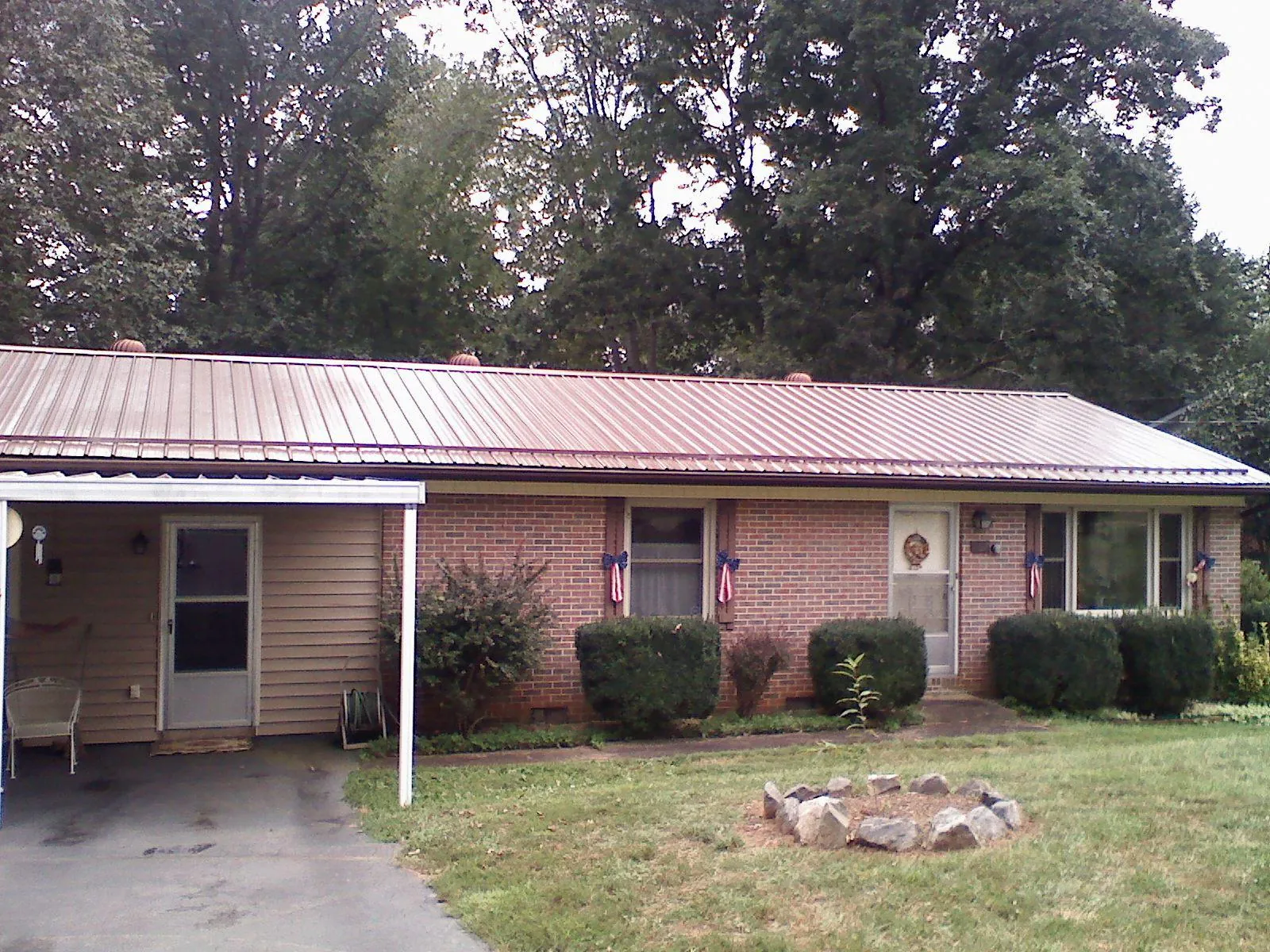 Bronze metal roof and carport on a brick ranch home — Roof Repair work by our crew in Blacklick